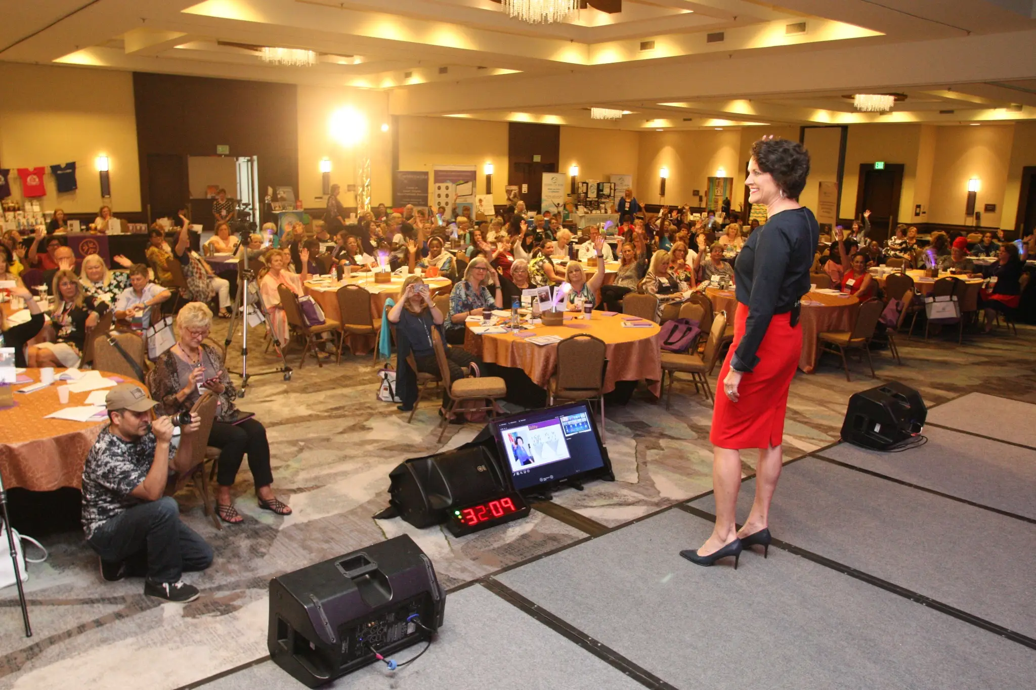 Marcella Scherer presenting to a large audience at a women’s leadership conference
